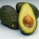 an avocado cut in half on a white surface