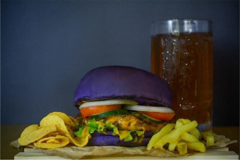 a hamburger and fries with a glass of beer